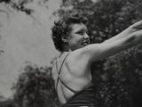 black and white photograph of a woman holding a bow and arrow