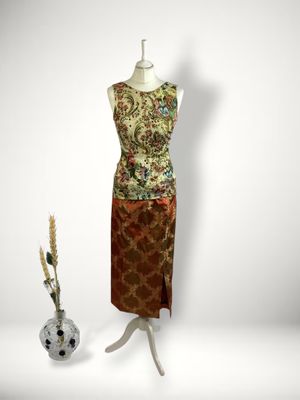 an image of a dress on a mannequin stand next to a vase of flowers