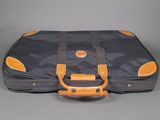 a black and orange suitcase sitting on a gray surface