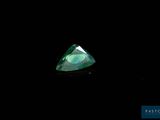 un gros plan d'un diamant vert sur fond noir