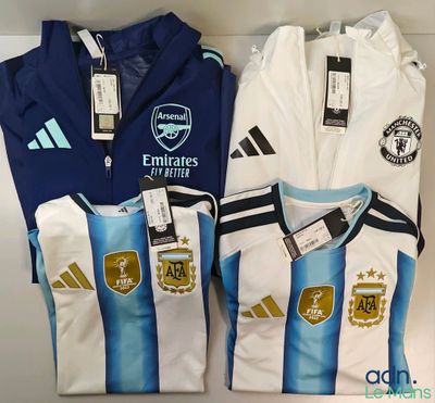 trois maillots de foot sont posés côte à côte sur une étagère