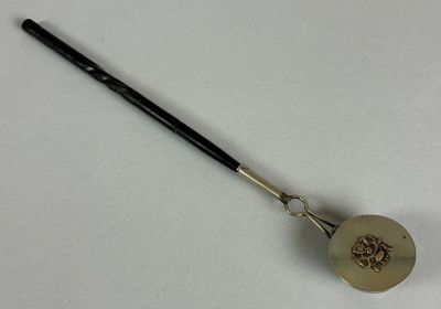 a small metal spoon with a handle on a white surface