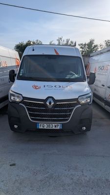 une camionnette blanche garée dans un parking à côté d'autres camionnettes