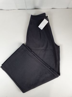 un pantalon noir posé sur une table blanche