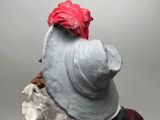 a clay sculpture of a man with a red hat on his head