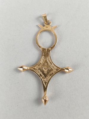 a close up of a gold cross on a white surface