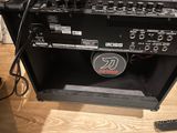 a guitar amp sitting on a wooden floor next to a remote control