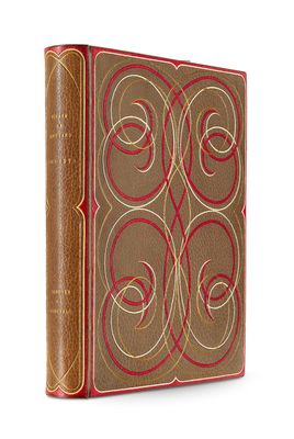an old book with a red cover sitting on top of a white surface
