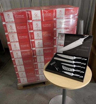 a box of knives on a table next to a stack of boxes