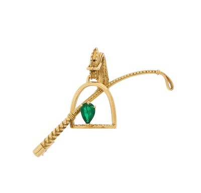 un gros plan d'une broche en or ornée d'un cœur vert