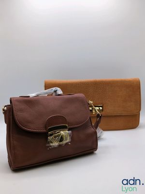 brown and brown purses sitting next to each other on a white surface