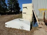 a broken refrigerator sitting in the dirt next to a building