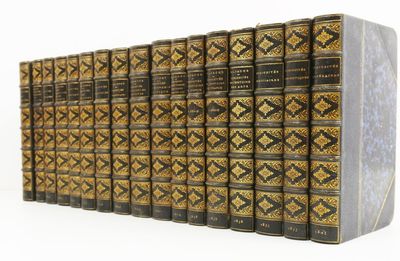 les dos des livres sont alignés sur une surface blanche