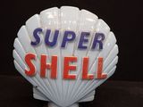 une enseigne en forme de coquillage sur laquelle est inscrit « Super Shell »