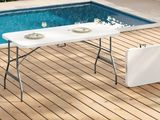 une table installée sur une terrasse en bois près d'une piscine