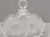 une bouteille en verre transparent surmontée d'une fleur