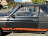 a black car with an orange stripe on the side of it