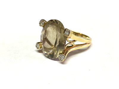 une image représentant une bague ornée d'une grosse pierre grise entourée de diamants