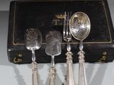 quatre cuillères en argent et deux cuillères en argent sur une table