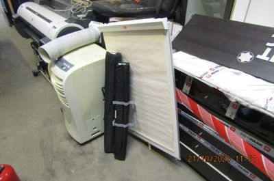 une pile de bagages posée par terre à côté d'un réfrigérateur