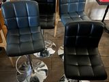 several black leather chairs are lined up in a row in a restaurant