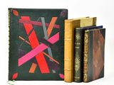 trois livres posés l'un à côté de l'autre sur une surface blanche