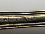 an image of a close up of a silver spoon with writing on it