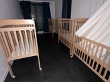 deux lits bébé dans une chambre avec des rideaux aux murs