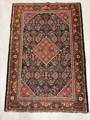 un tapis ancien orné d'un motif en losanges sur fond blanc