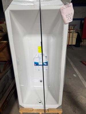 une baignoire blanche posée sur une palette dans un entrepôt