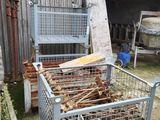 a metal cage with a pile of wood inside of it