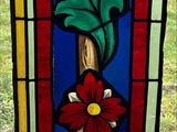 a stained glass window with a red flower on it