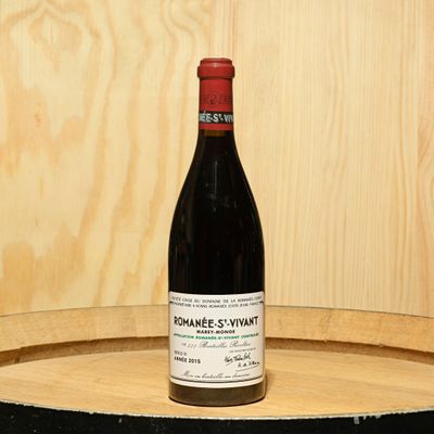 a bottle of wine sitting on top of a barrel
