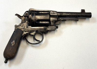 un pistolet posé sur une surface blanche