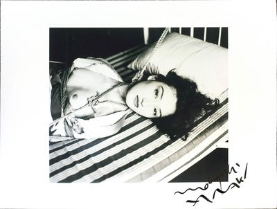 a black and white photo of a woman laying on a bed