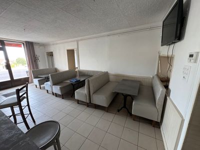 a living room with couches, tables, chairs and a flat screen tv