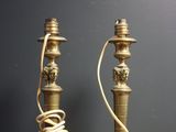 une paire de bougies anciennes en laiton posées sur une table en bois, avec des fils métalliques
