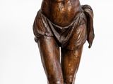 statue en bronze représentant un homme tenant une croix, sur fond blanc
