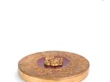 gold plate with a pink glass in the middle of it on a white surface