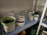 many dishes and cups on the shelf in the kitchen
