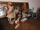 de nombreuses figurines d'animaux posées sur une table à côté d'un tableau encadré