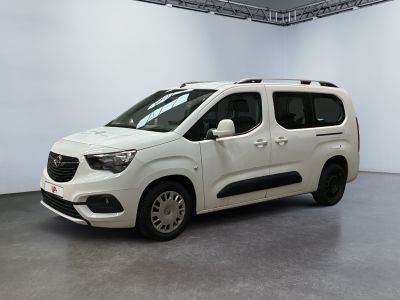 La camionnette blanche est garée dans une grande pièce blanche.
