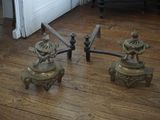 une paire de bougies anciennes en laiton posées sur un parquet
