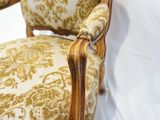 a close up of a chair with a gold and white pattern