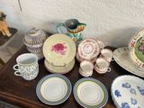 many plates and cups on a table with a teddy bear