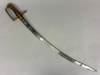 un gros plan d'une épée posée sur une surface blanche, avec une poignée dorée