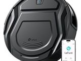 une image représentant un robot aspirateur noir avec un smartphone à côté