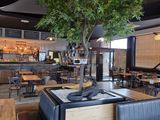 des tables et des chaises dans un restaurant avec un arbre au milieu de la salle