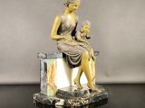 statue of a woman sitting on a marble block holding a baby