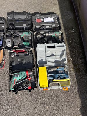 beaucoup d'outils posés par terre à côté d'une voiture